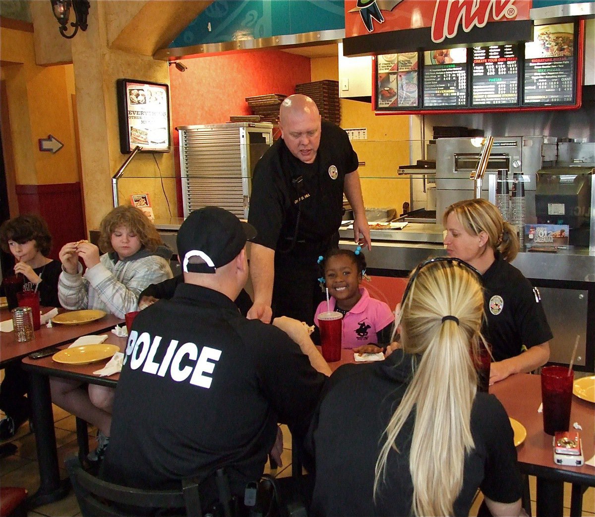 Image: Chief Hill offers some more slices of pizza to Mariah.