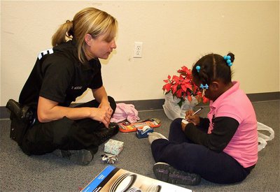 Image: Officer Tierra Mooney helps Mariah write out her Christmas tag. When asked who her favorite police officer was? Mariah said, "Officer “Tooney” Mooney."