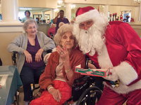 Image: Santa helping to spread a little Christmas cheer by handing out candy canes and hugs.