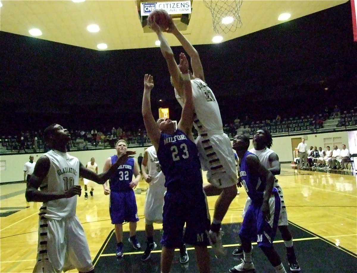 Image: 6’, 8" Cole Hopkins(21) out leaps the Milford Bulldogs for a rebound.