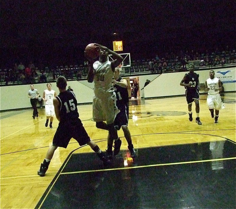 Image: Devonta Simmons(10) squeezes between two Zebra defenders to put up the shot.