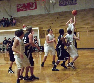 Image: JV Gladiator Cody Boyd(10) pulls up along the baseline with Chace McGinnis(12), Zain Byers(5) and John Escamilla in position to rebound against Grandview.