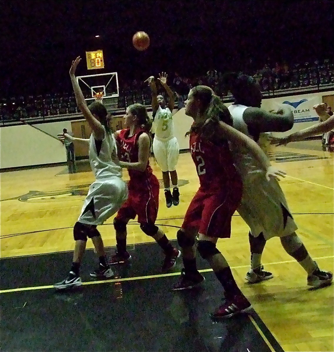 Image: Jameka Copeland(5) shoots a jump shot while teammates Kaitlyn Rossa(3) and Jimesha Reed(40) jockey for position.