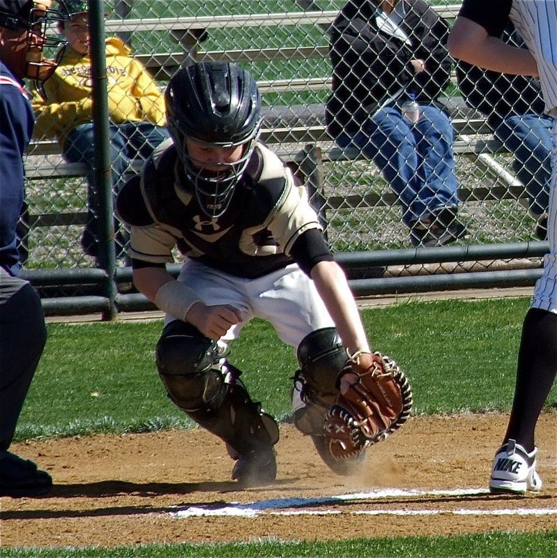 Image: JV Gladiator catcher John Escamilla manages to grasp a low pitch.