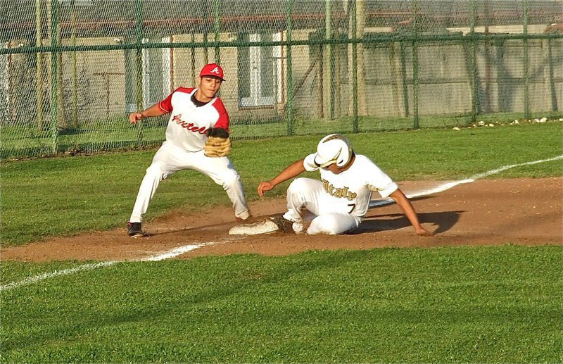 Image: A stealing Omar Estrada(7) beats the throw to third base.