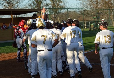 Image: Marvin Cox celebrates at home with his teammates after his monster shot over the left field fence.