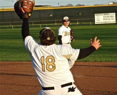 Image: Chace McGinnis(2) confidently fires a throw to Hank Seabolt(18) for an out at first base.