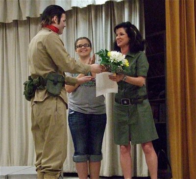 Image: Captain Kuroda, I mean, Gus Allen, presents IHS Drama Club director, Andi Windham, a bouquet of flowers for all her devotion to the club as crew member, Reagan Adams, applauds the moment.