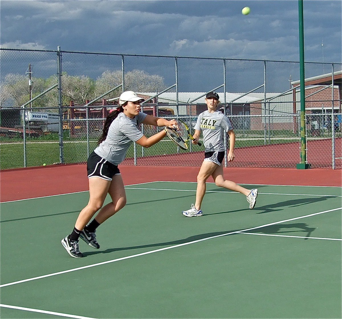 Image: Alyssa Richards returns the ball while Megan Richards backs her little sister up.