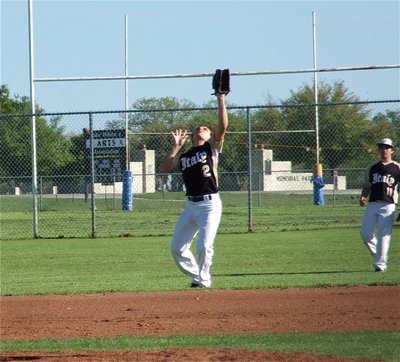 Image: Shortstop Chace McGinnis(2) catches a fly ball with teammate Tyler Anderson(11) backing him up.