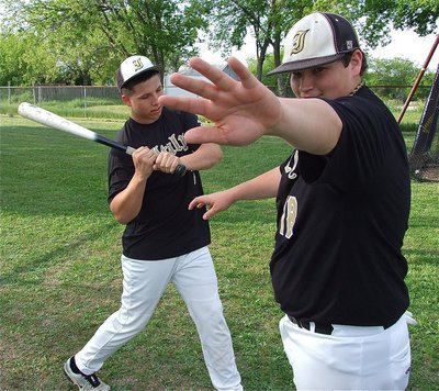 Image: John Byers(18) tries to keep the cameras away from senior slugger, Kyle Jackson(7), with Jackson requiring some alone time during his pre-game ritual.