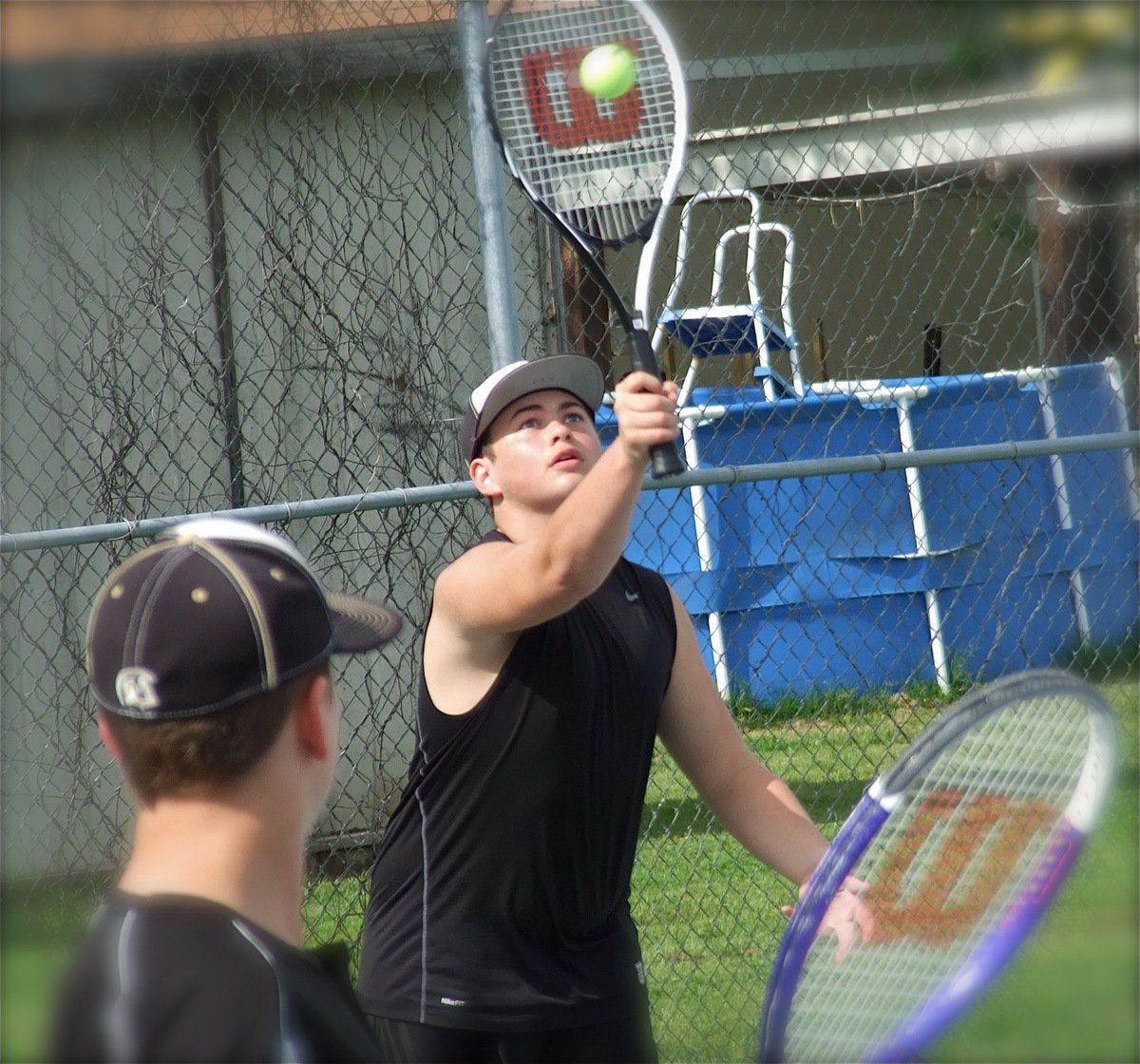 Image: Italy’s Zain Byers serves up a winner in a doubles match with teammate Bailey Walton.