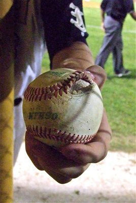 Image: Italy’s, Hayden Woods displays the busted baseball covering after teammate, Justin Buchanan, took a swing at it. 