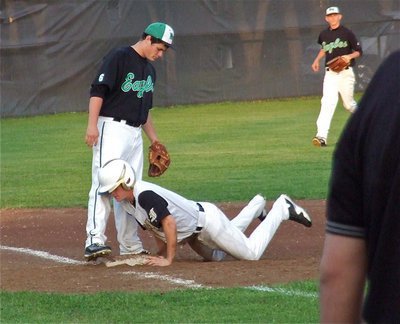 Image: Italy’s, Hayden Woods slides safely into the third base sack.
