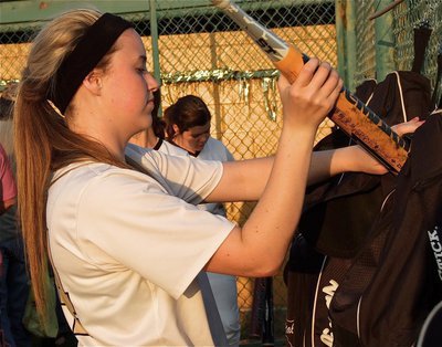 Image: Lady Gladiator left fielder, Kelsey Nelson(14) packs away her gear to get ready for Axtell on April 3rd as does teammate Bailey DeBorde(1).