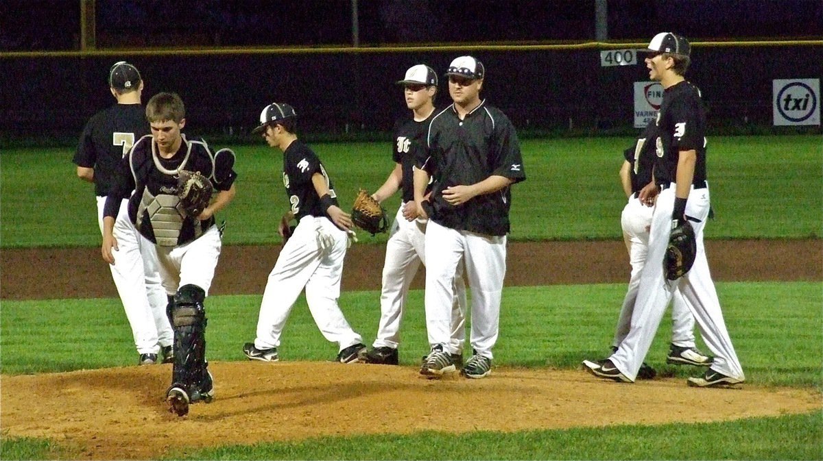 Image: Coach Ward and the Gladiator infielders support their pitcher Justin Buchanan.