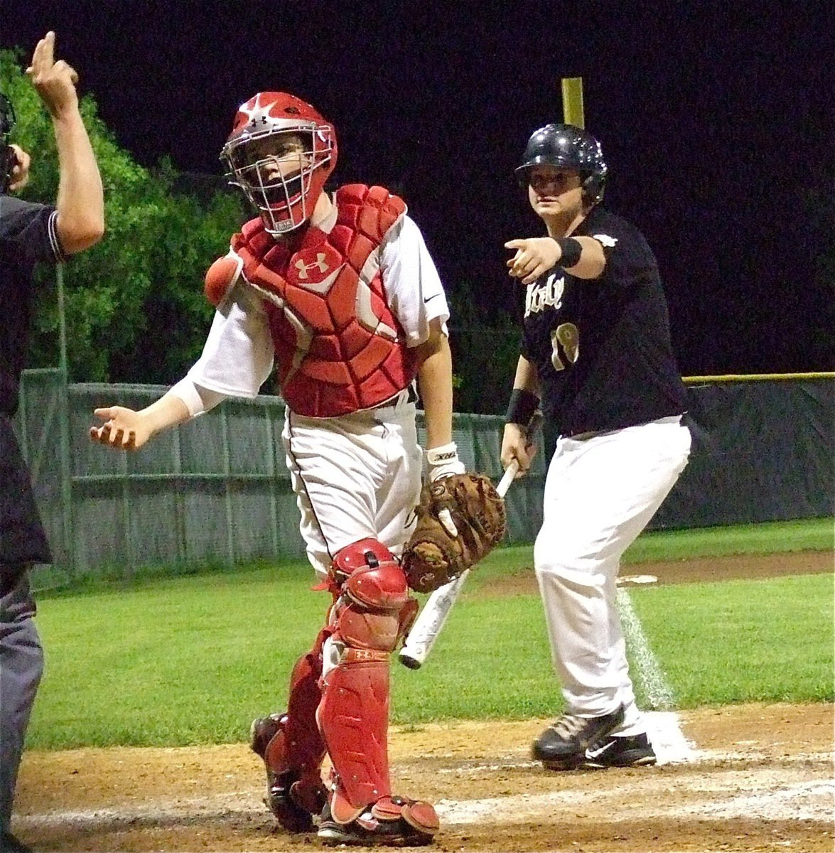 Image: Italy’s, John Byers(18) argues that their was catcher interference during his swing but the call is later overturned.