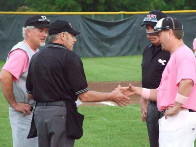 Image: Umpires and coaches shake hands before the game.