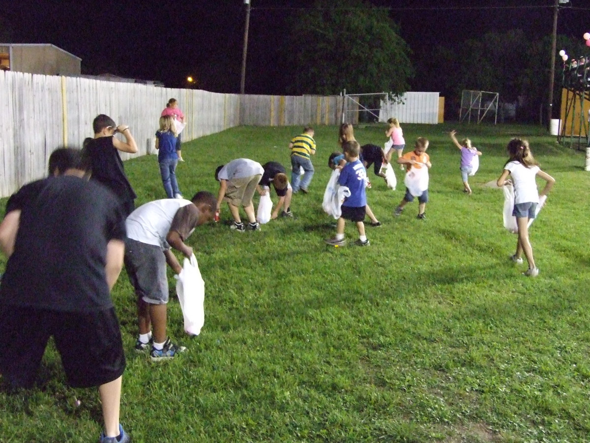 Image: The children scooped up candies and momentos outside of home dugout.