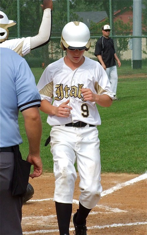 Image: Cody Boyd(9) and teammate Marvin Cox score off a Kevin Roldan single.