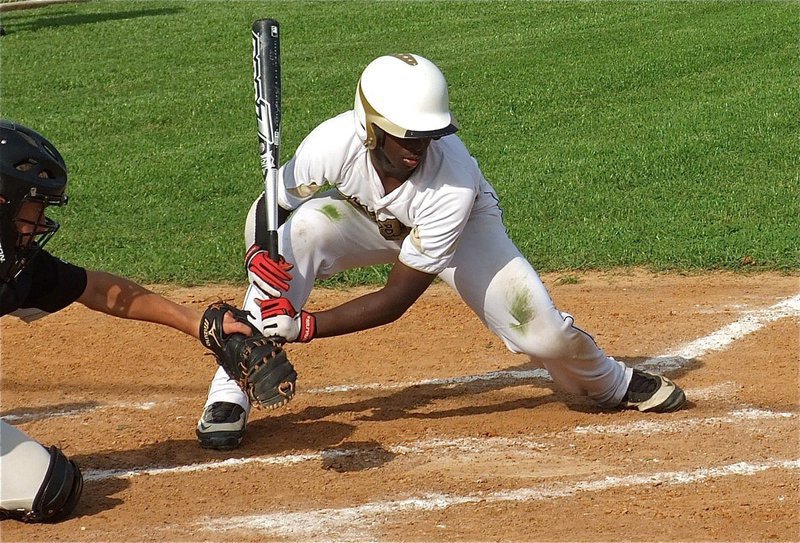 Image: Marvin Cox tries to deal with the umpires low strike zone.