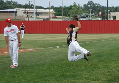 Image: Italy’s First baseman, Kevin Roldan(16), dives for a foul ball that blew off course by gusty winds in Glen Rose.