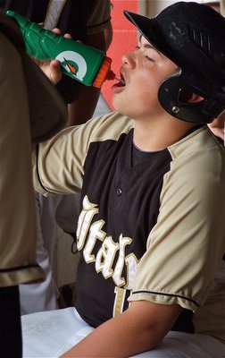 Image: Zain Byers, refreshes in the dugout before his at bat.