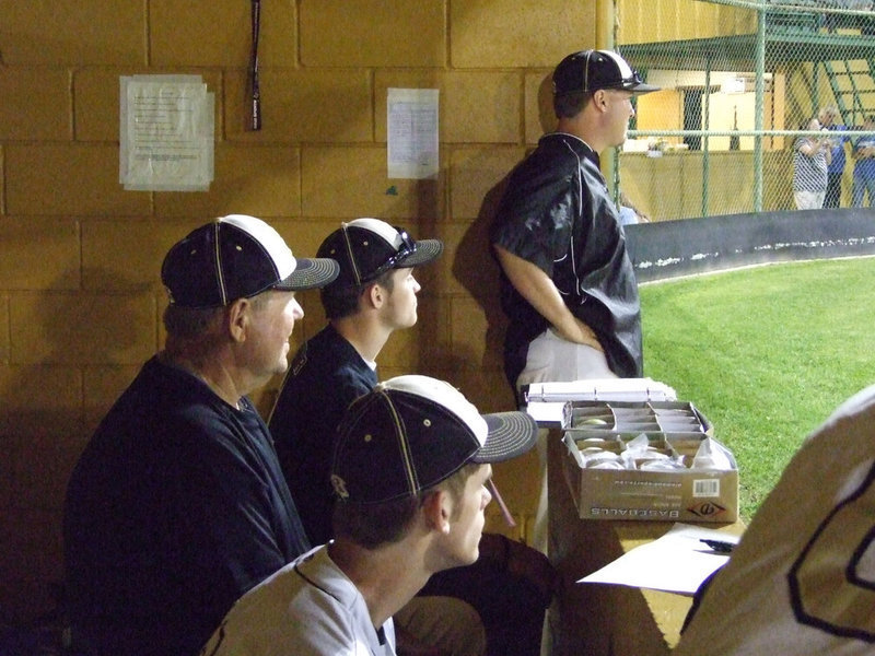 Image: Coaches and players watching the game intently.