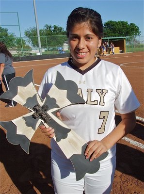 Image: Alma Suaste(7), displays her wooden cross.