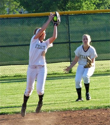 Image: Bailey Bumpus(18) hauls in a popup at shortstop while being backed up by centerfielder, Madison Washington(2).