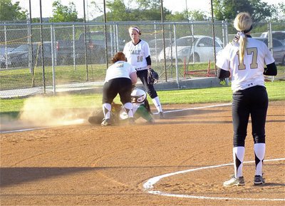 Image: Pitcher, Megan RIchards(17) looks on as third baseman, Katie Byers(13), swings around for a possible tag with shortstop, Bailey Bumpus(18), backing up the play.