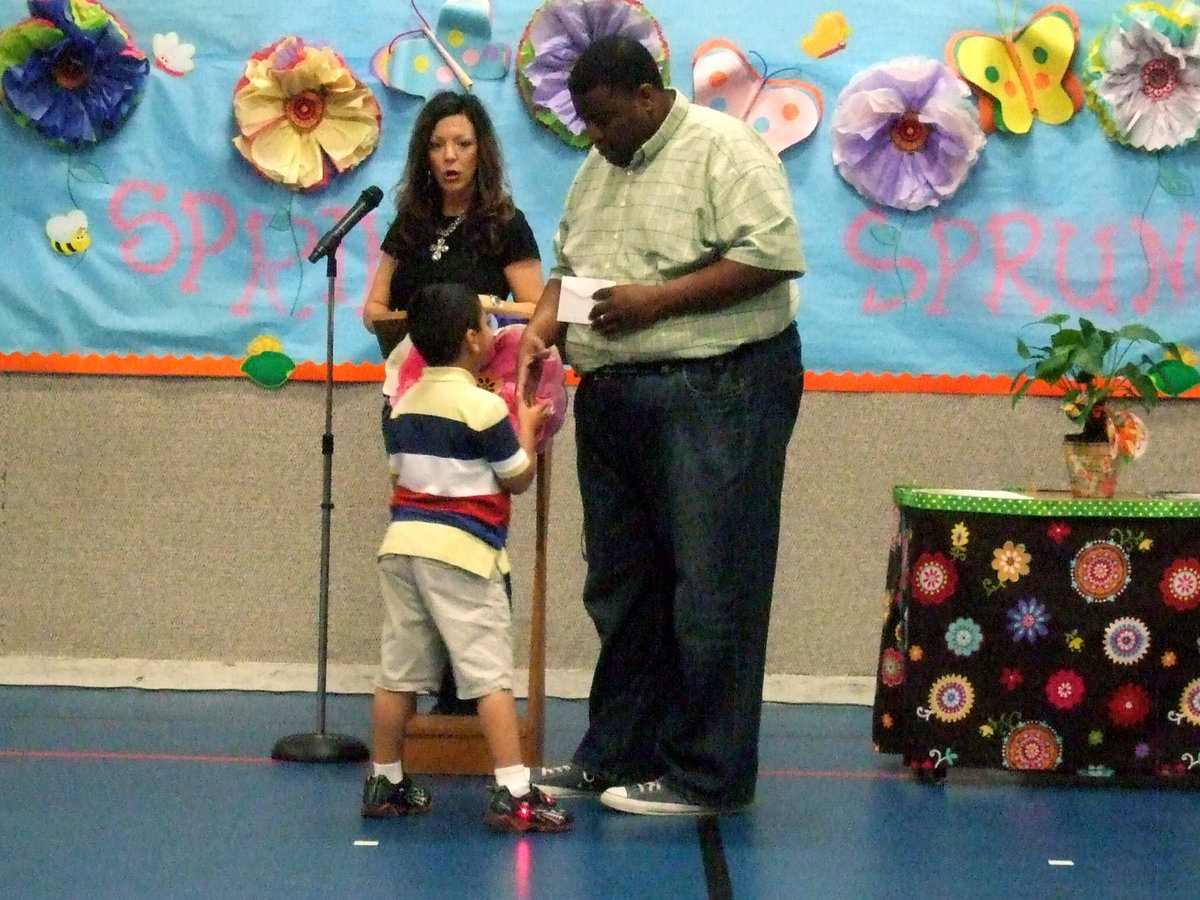 Image: This young man proudly shakes Mr. Miller’s hand.