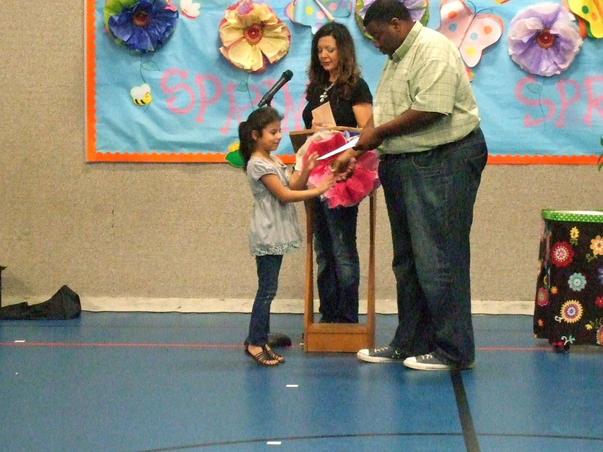 Image: She is up on her tip toes to get her award.