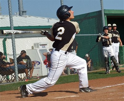 Image: Chace McGinnis(2), sends one high as his JV Gladiator teammates look on from the dugout.
