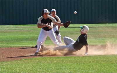 Image: Zain Byers(10), backs up shortstop, Chace McGinnis(2), while attempting to tag out a stealing Eagle runner during the JV game.