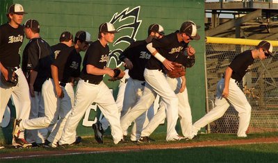 Image: Chase Hamilton(10), Jase Holden(3) and their Gladiator teammates storm out of the dugout.