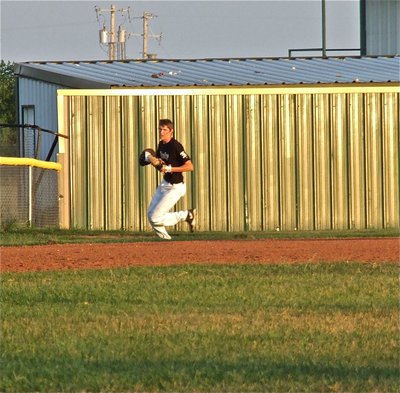 Image: Alex DeMoss(4) makes a running grab in left field.