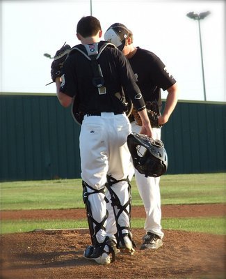 Image: Catcher and pitcher strategize as Ross Stiles(1) meets with Justin Buchanan(13).