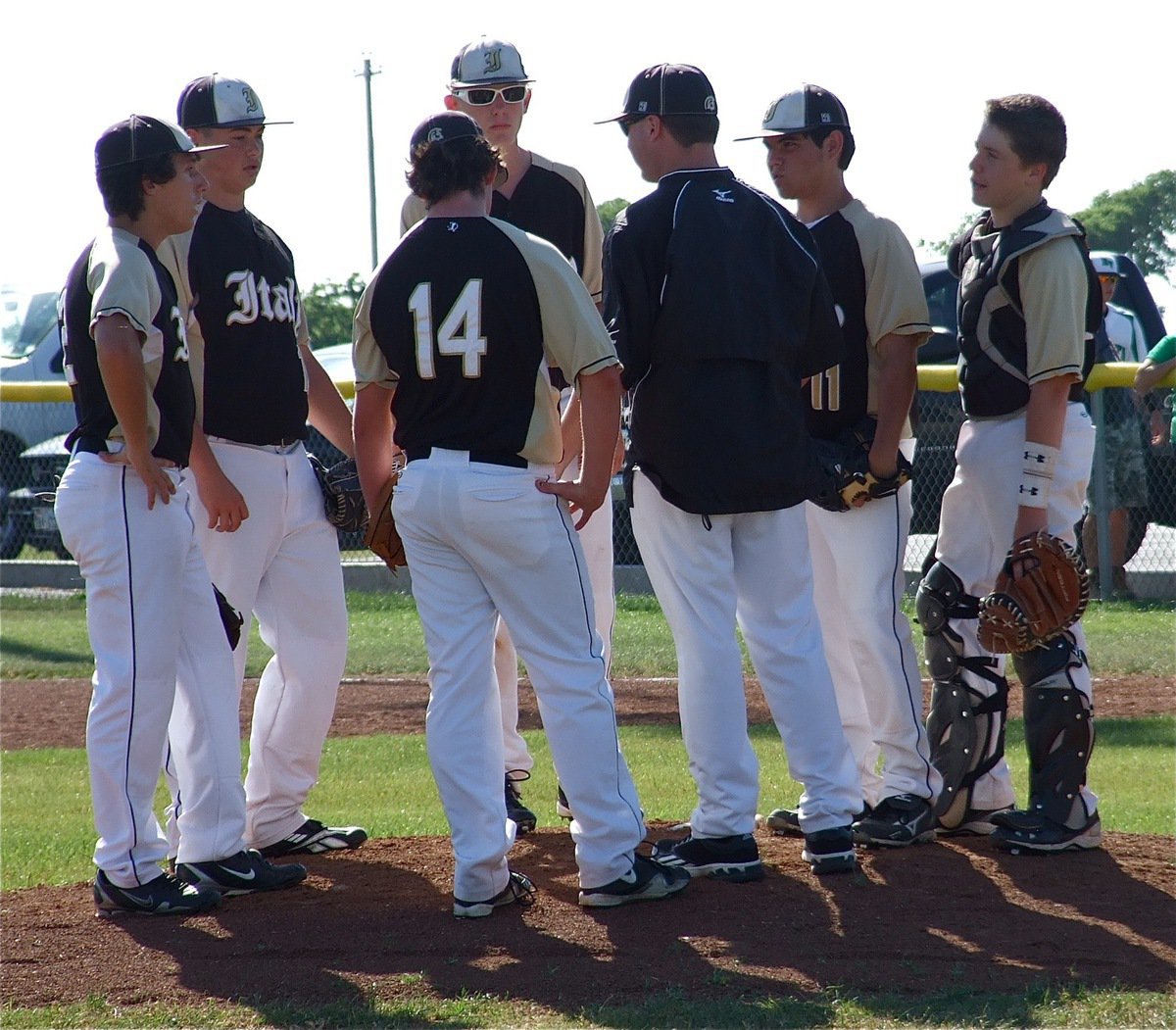 Image: JV Gladiator infielders chat with Coach Josh Ward on the mound.