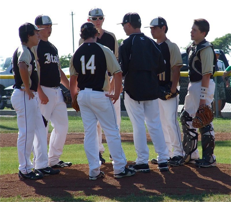 Image: JV Gladiator infielders chat with Coach Josh Ward on the mound.