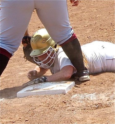 Image: Katie Byers(13) dives back to the first base back with Mildred respecting her speed.