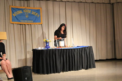 Image: Susana Rodriguez lights the “Character” candle.