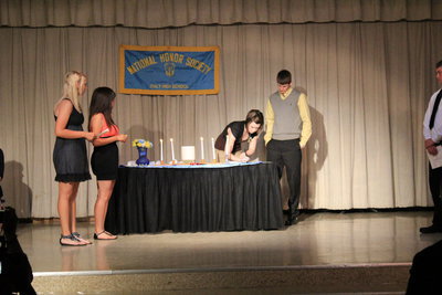 Image: Meagan Hooker (junior) signs the NHS book.