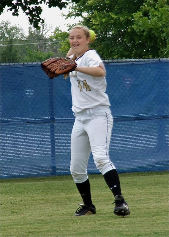 Image: Freshman Lady Gladiator, Kelsey Nelson(14), is all smiles while catching a popup during warmups.
