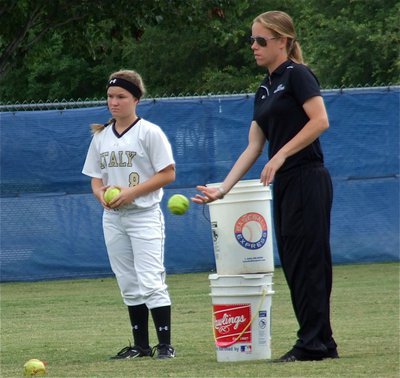 Image: Head Lady Gladiator softball coach, Jennifer Reeves, works on bunting with her players as Tara Wallis(8) looks on.