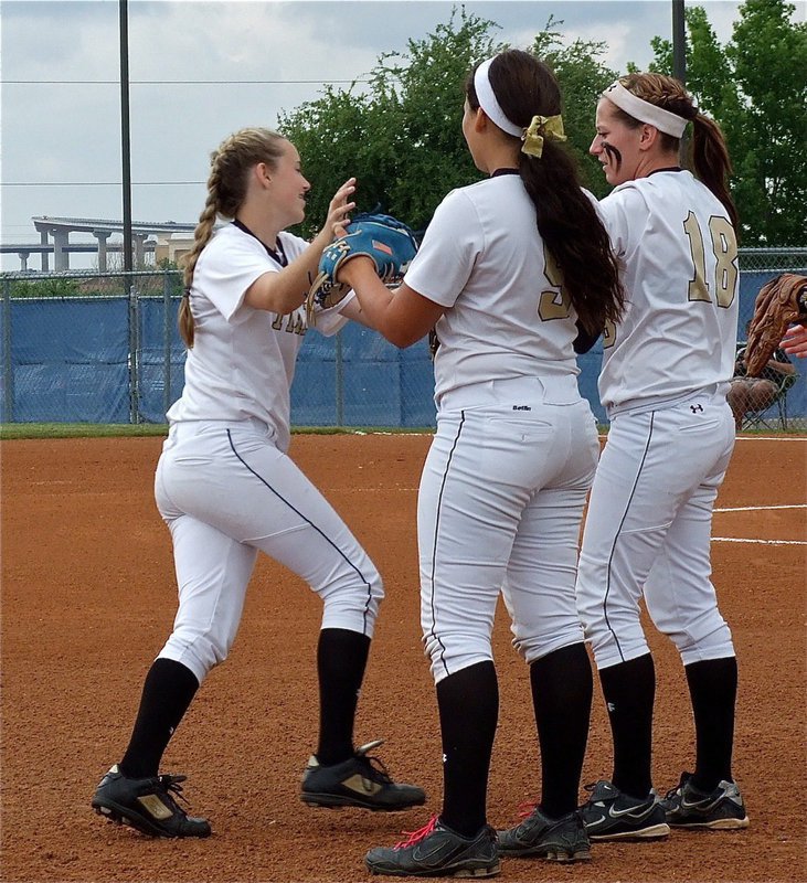 Image: Kelsey Nelson(14) gets cheered on by teammates Alyssa Richards(9) and Bailey Bumpus(18).