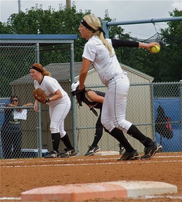 Image: Megan Richards(17) steps into the pitch as third baseman, Katie Byers(13), inches toward home plate.