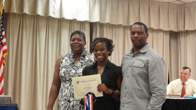 Image: State track champion, Kortnei Johnson with her parents, Stephanie and James.