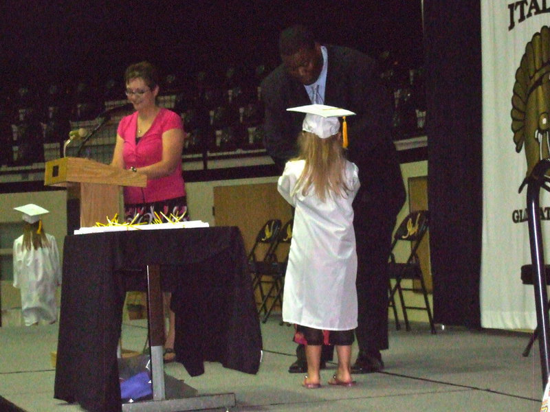 Image: Mr. Miller congratulating this student and giving her, her diploma.