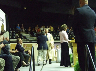 Image: Clayton Campbell shakes Larry Eubank’s hand and graduates with a smile.